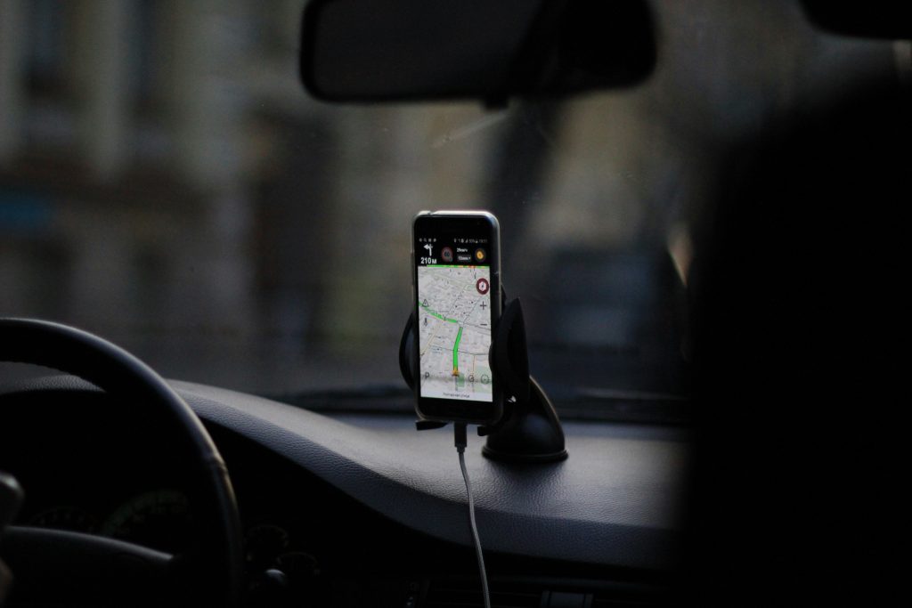 Ein Smartphone zeigt eine GPS-Route in einem Auto, ideal für moderne Fahrzeugortungslösungen.