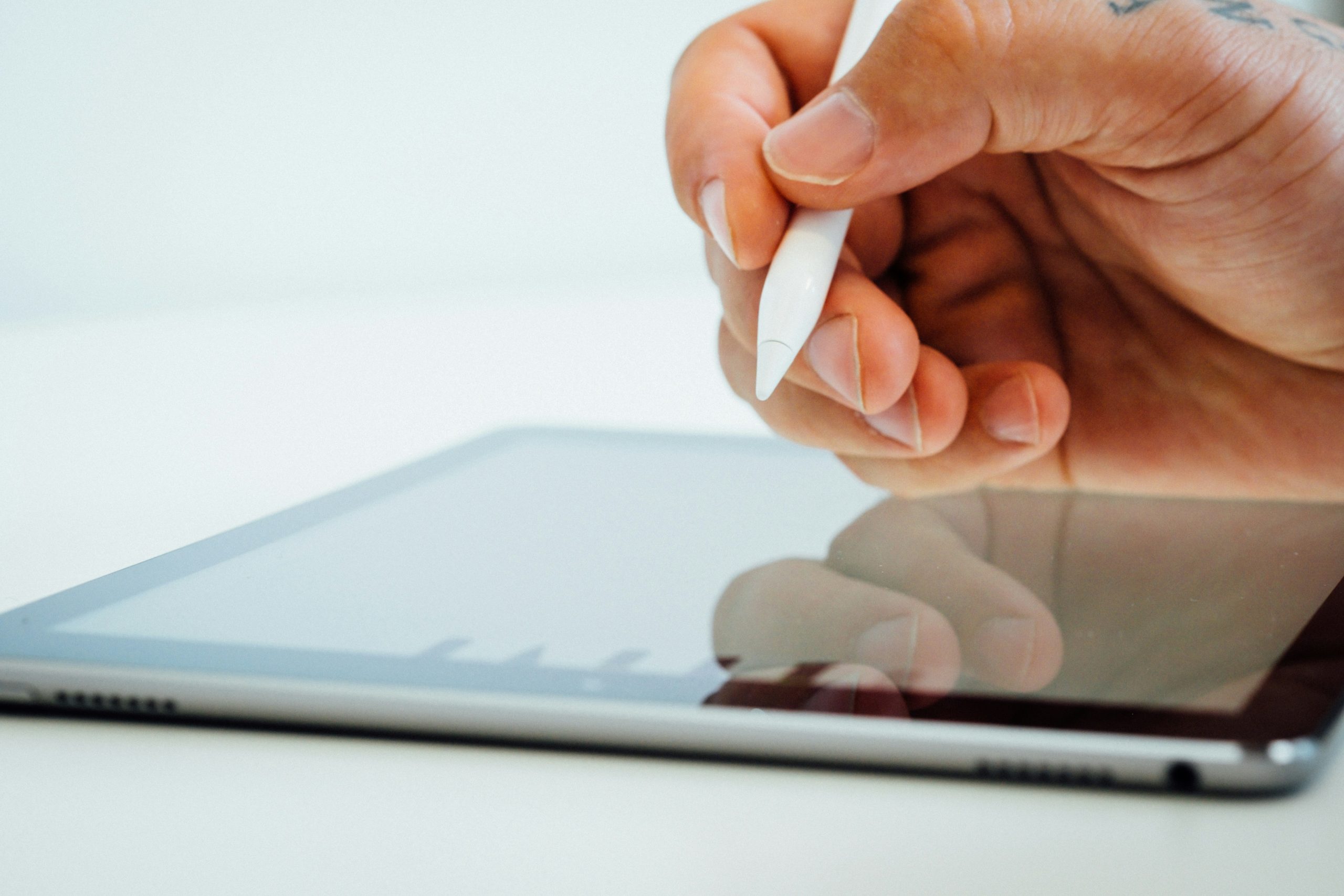 Eine Hand hält einen Stylus und berührt einen Tablet-Bildschirm zur Fahrzeugortung mit modernster GPS-Technologie.